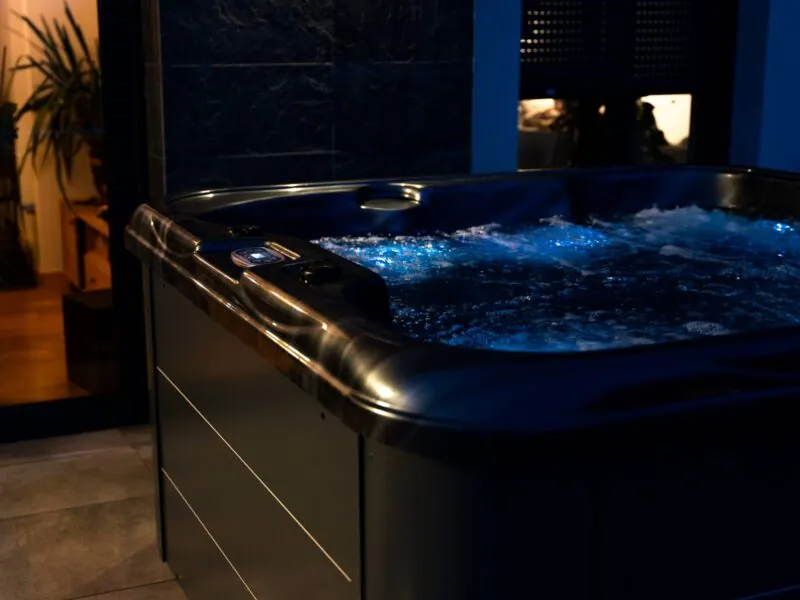 Wanna spa z iluminacją LED, widoczne świecące dysze i podświetlona woda.
